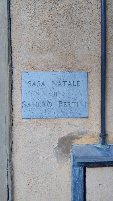 La targa commemorativa della casa natale di Sandro Pertini, affissa su un muro.