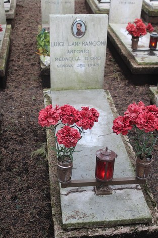 Tombe perpetue con fiori rossi e candele, commemorano i caduti per la Libertà in un cimitero.