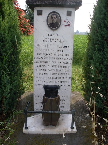 Cippo in memoria di Asseverati, dedicato ai caduti della guerra, con simboli e iscrizioni commemorative.