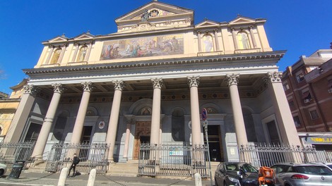 Lapide commemorativa sulla facciata della chiesa di San Gioacchino, con colonne e architettura imponente.