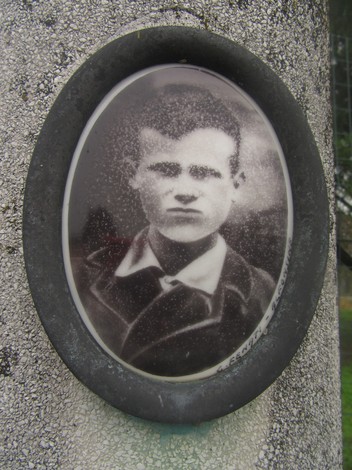 Cippo a Tavalazzi, monumento commemorativo con ritratto in bianco e nero su base di pietra.