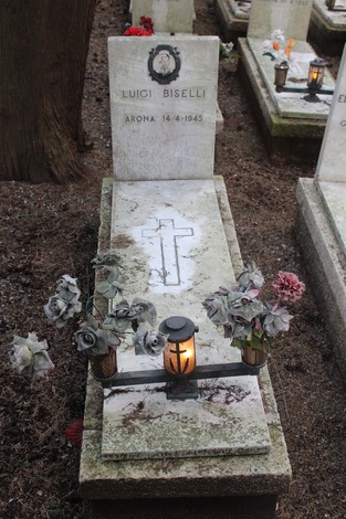 Tombe con fiori e candelabri, dedicate ai caduti per la Libertà, in un cimitero ordinato e rispettoso.