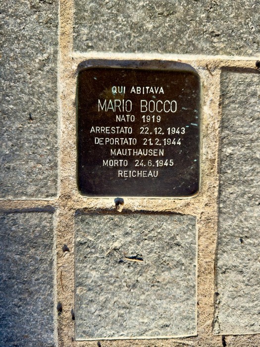 Pietra d'inciampo in ottone incastonata nella pavimentazione in pietra, con iscrizione dedicatoria.