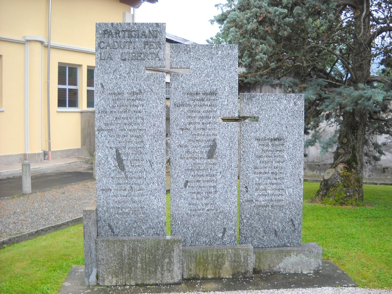 Monumento in pietra dedicato ai partigiani, con incisi nomi e ricordi di coloro che combatterono per la libertà.