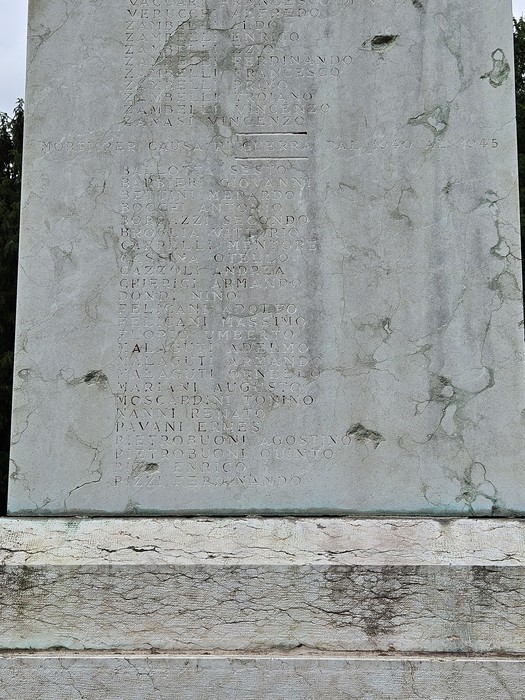 Monumento ai Caduti con iscrizioni commemorative su una struttura in pietra, visibile segni del tempo.