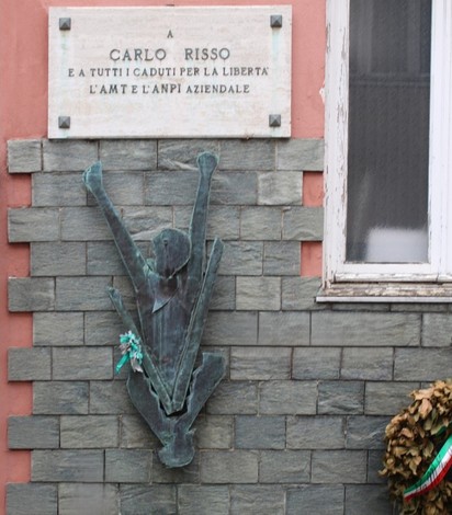 Monumento a Risso, commemorazione con statua bronzea e targhe informative su un muro di pietra.