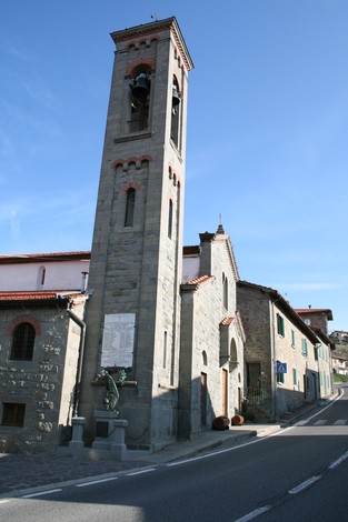 Lapide della chiesa della Consuma, con campanile e facciata in pietra, situata lungo la strada.