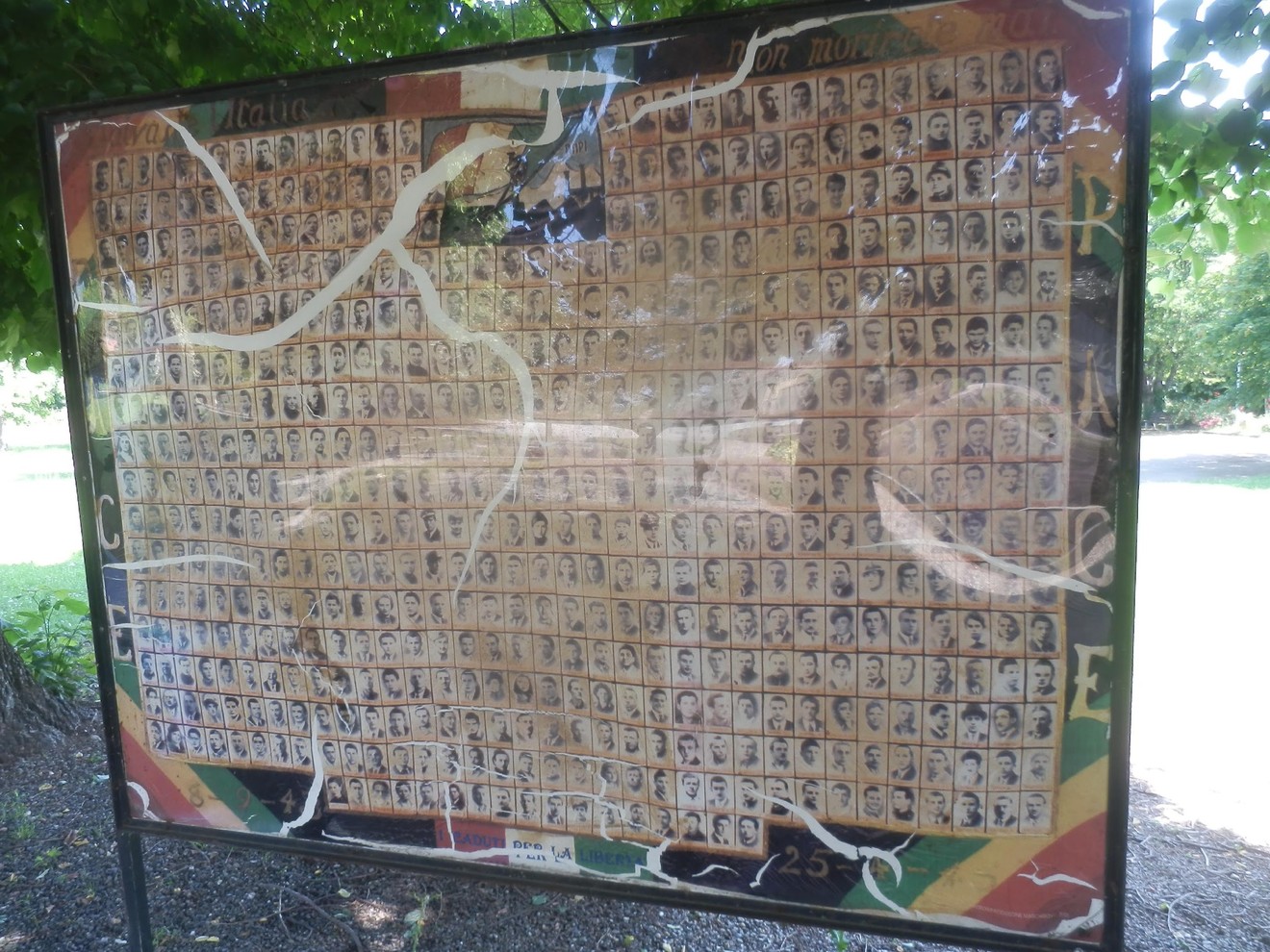 Pannello commemorativo con volti di caduti per la libertà, in memoria dei sacrifici per l'indipendenza.
