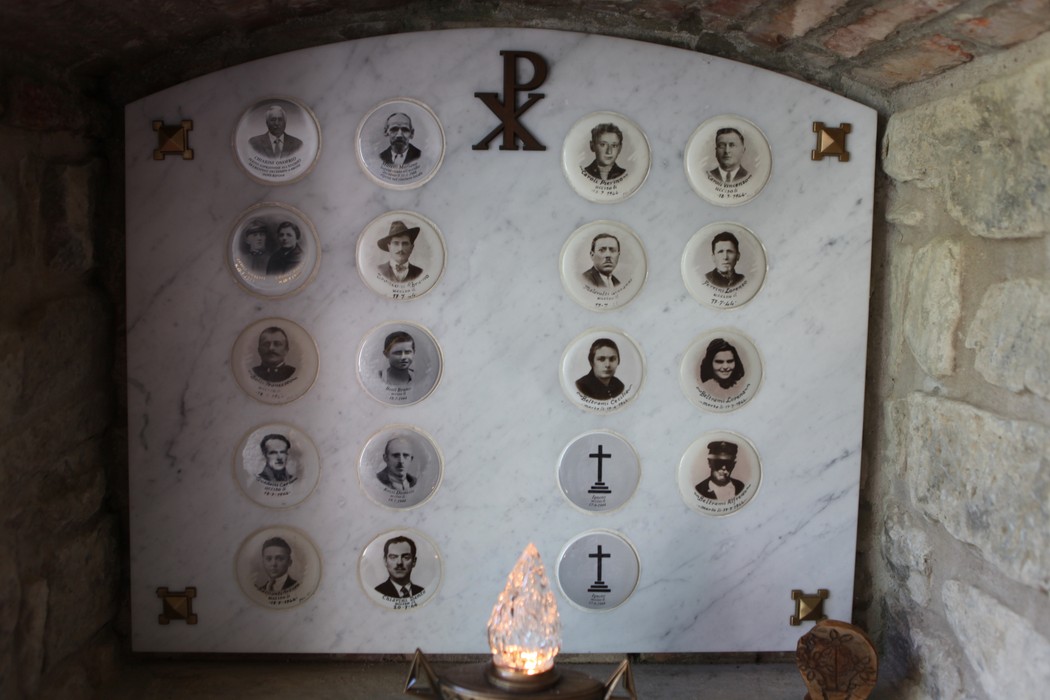 Ossario di Crespino del Lamone, monumento commemorativo con ritratti su piatti di ceramica.