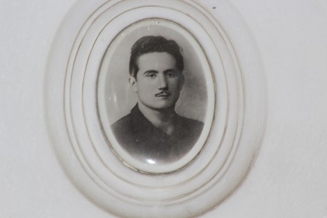 Ritratto in bianco e nero incastonato, raffigurante un uomo con baffi e sguardo serio, evocando la memoria partigiana.