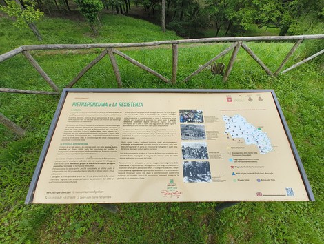 Lapidi informative su Pietraporciana, situate in un contesto naturale, con una mappa e fotografie storiche.