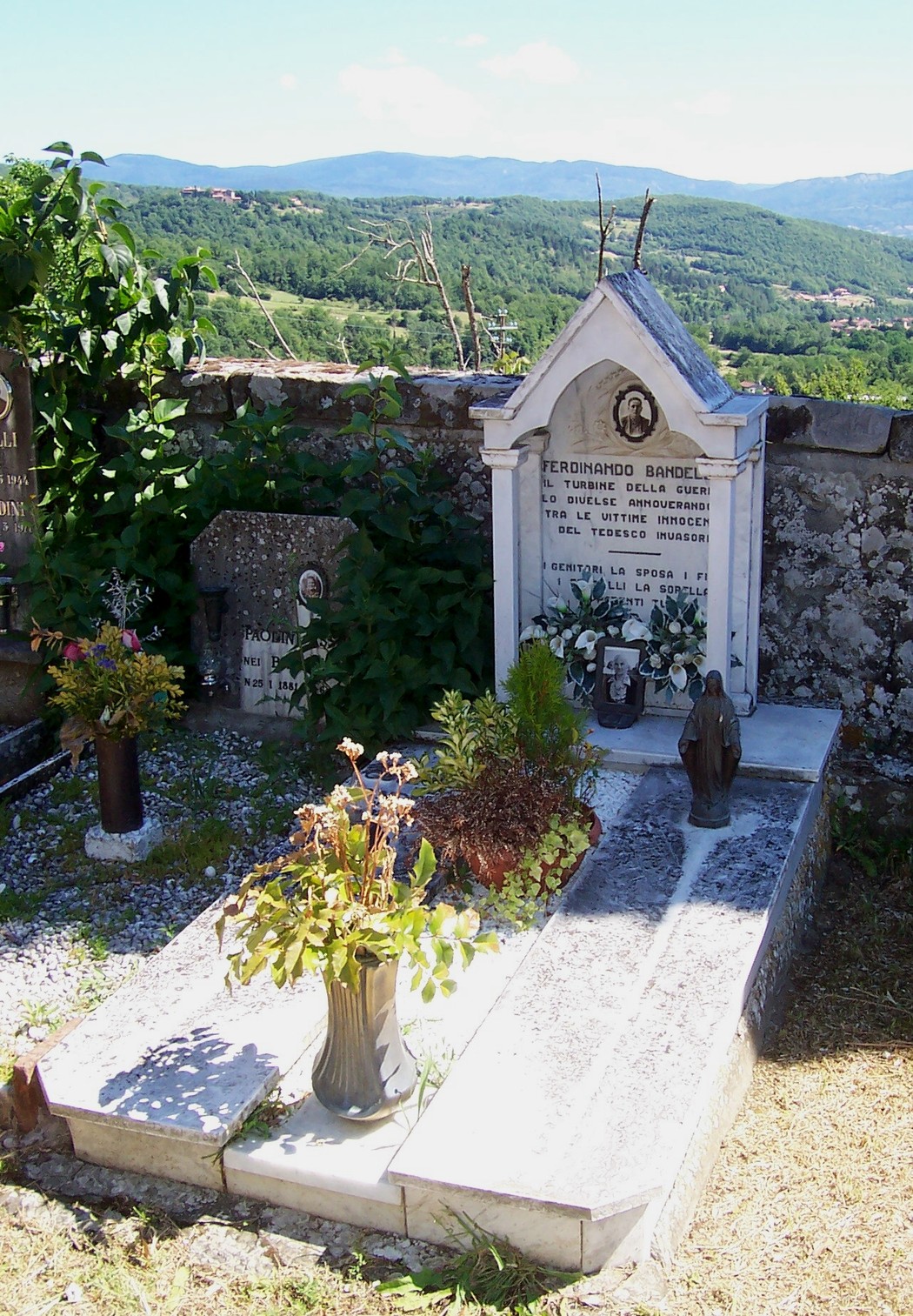 Sepolcro di Bandelloni, un luogo di memoria immerso nel verde, con fiori e un'atmosfera di tranquillità.