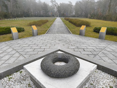 Cimitero militare italiano di Zehlendorf con un sentiero centrale e monumento commemorativo circondato da alberi.