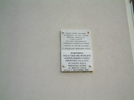 Lapide commemorativa della Casa del Mutilato, in ricordo dei sacrifici e delle sofferenze dei veterani.