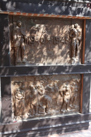 Monumento ai Martiri del Panaro con rilievi che commemorano eventi della Seconda Guerra Mondiale.