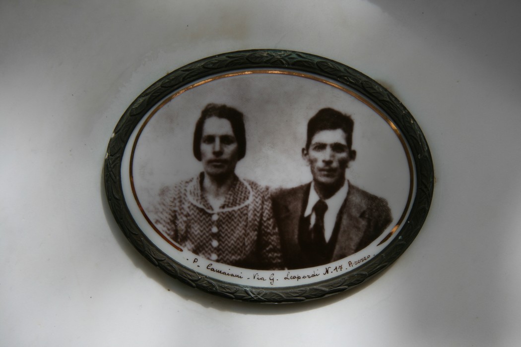 Lapide commemorativa della famiglia Buzzini con un'immagine di due persone in posa.