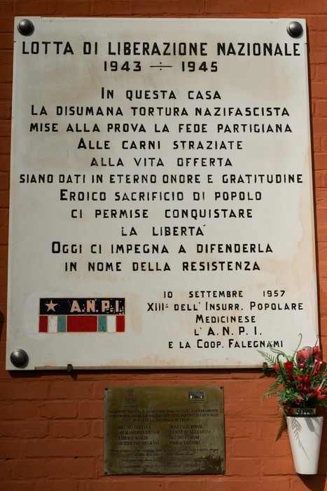 Lapide commemorativa dedicata alla lotta di liberazione nazionale, con riferimento a eventi storici e all'impegno della resistenza.