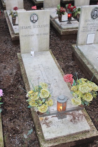 Tombe perpetue dei caduti per la Libertà, decorate con fiori e luci in un cimitero.