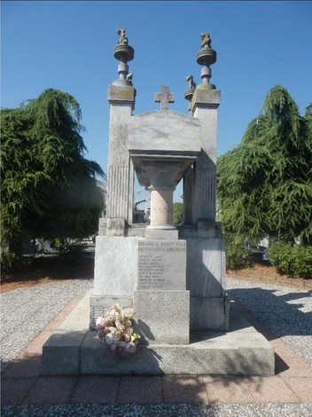 Monumento dedicato ai caduti della lotta di Liberazione, circondato da alberi e fiori.