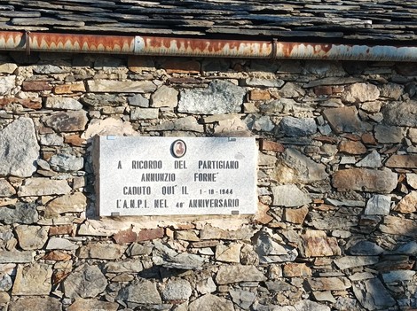 Lapide commemorativa del partigiano Annuizio Fornè, situata su una parete in pietra.