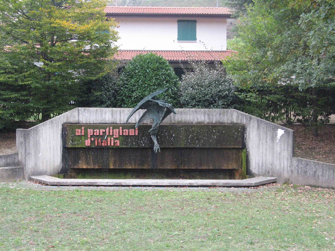 Monumento ai partigiani di Pian di Macina, con una scultura e una fontana in un contesto verde e tranquillo.