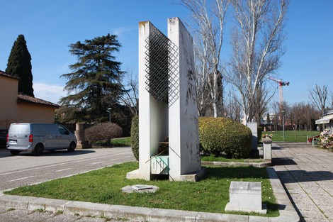 Monumento agli Internati Militari italiani, struttura minimalista in un contesto urbano con verde e alberi.