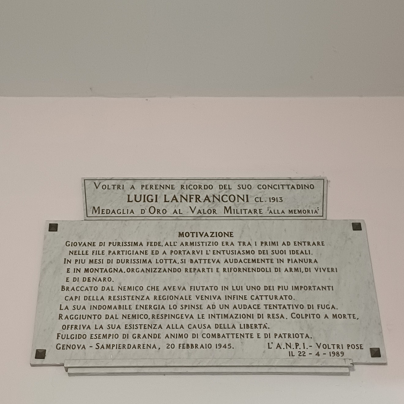 Due targhe in marmo affisse a una parete chiara, con iscrizioni dedicate a Luigi Lanfranconi.