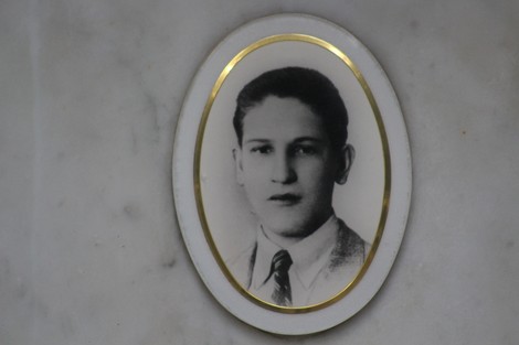 Ritratto di un giovane in bianco e nero, incastonato in un ovale con cornice dorata, su fondo marmoreo.