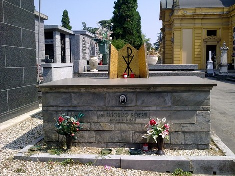 Sepolcro di Borghi, un luogo di memoria e riposo, adornato con fiori e simboli religiosi.