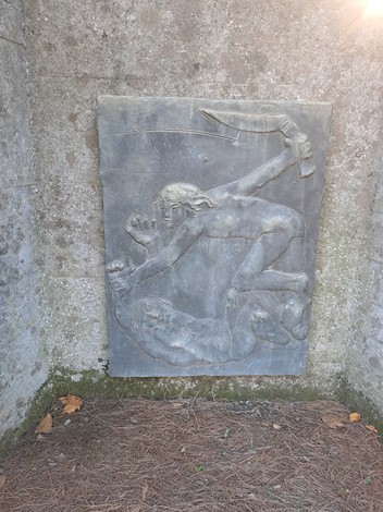Rilievo monumentale che rappresenta una scena drammatica in onore dei caduti. Dettagli intensi e espressivi.