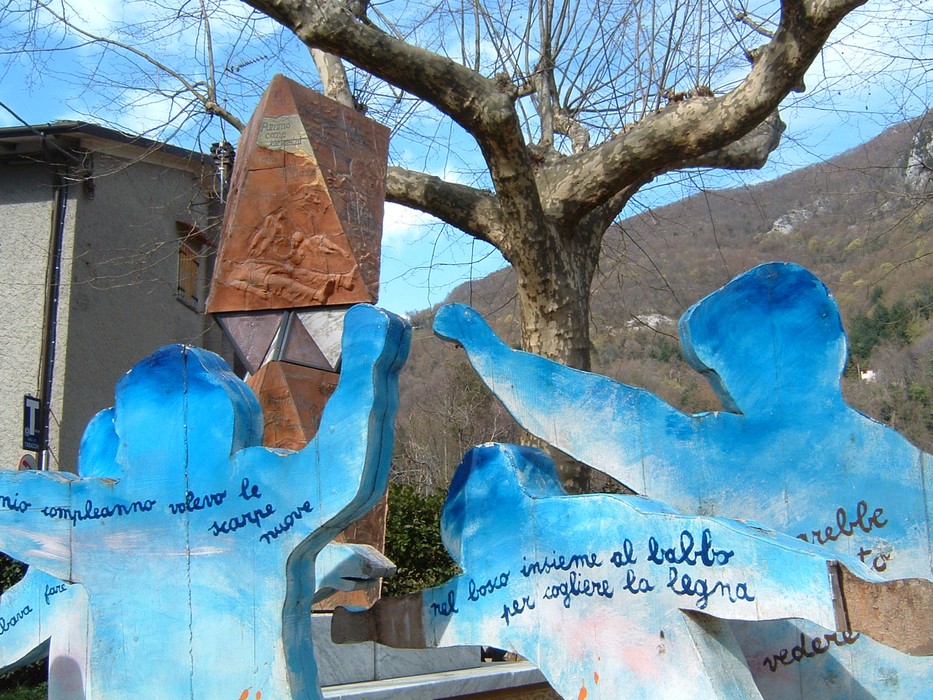 Monumento della piazza di Sant'Anna con sculture e un albero che si staglia sullo sfondo.