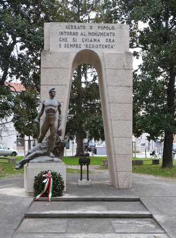 Monumento alla Resistenza, con scultura commemorativa e decorazione tricolore, simbolo di lotta e libertà.
