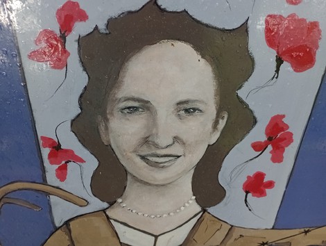 Ritratto femminile con fiori rossi sullo sfondo, caratterizzato da un sorriso sereno e dettagli artistici.