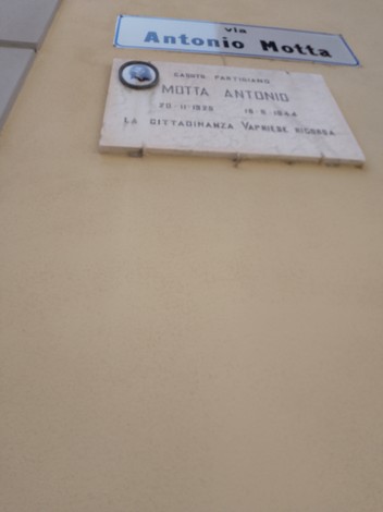 Lapide commemorativa dedicata a Antonio Motta, situata su un muro in via a lui intitolata.