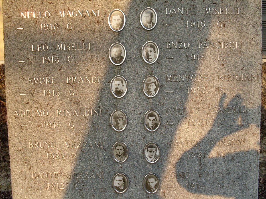 Monumento ai Caduti di Massenzatico, commemorazione degli eroi locali con le loro immagini e nomi incisi.