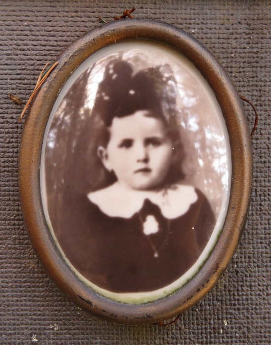 Ritratto vintage in bianco e nero di una bambina con abito scuro e colletto bianco.