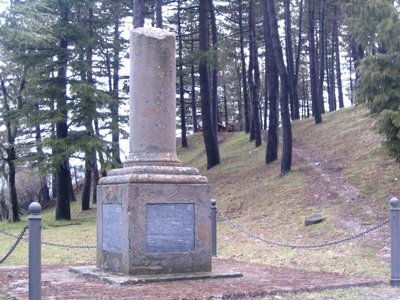 Monumento ai caduti partigiani dell'11 agosto 1944, immerso nella natura e circondato da alberi.