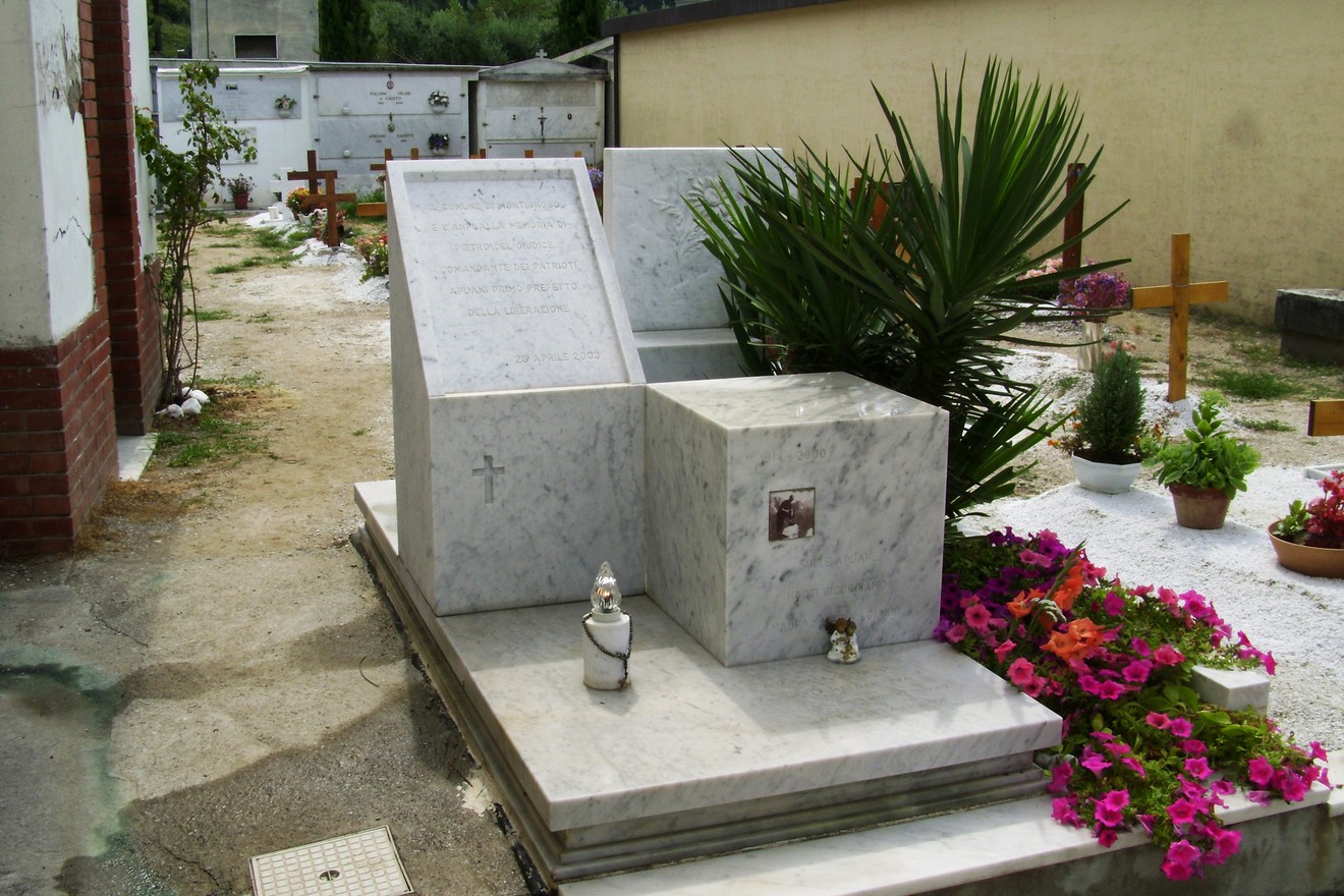 Sepolcro di Del Giudice, con decorazioni floreali e un ambiente tranquillo nel cimitero.