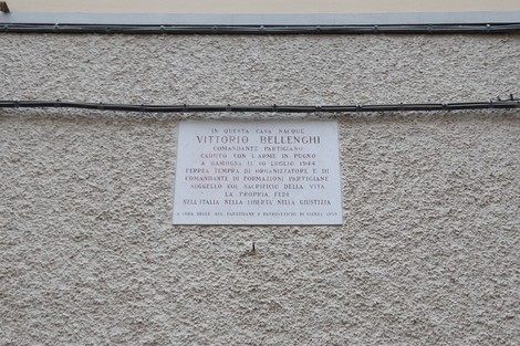 Lapide commemorativa di Vittorio Bellenghi, partigiano, situata sulla facciata di una casa storica.