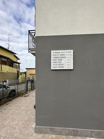 Lapide commemorativa ai caduti di Secchia, con nomi e date in memoria delle vittime della guerra.