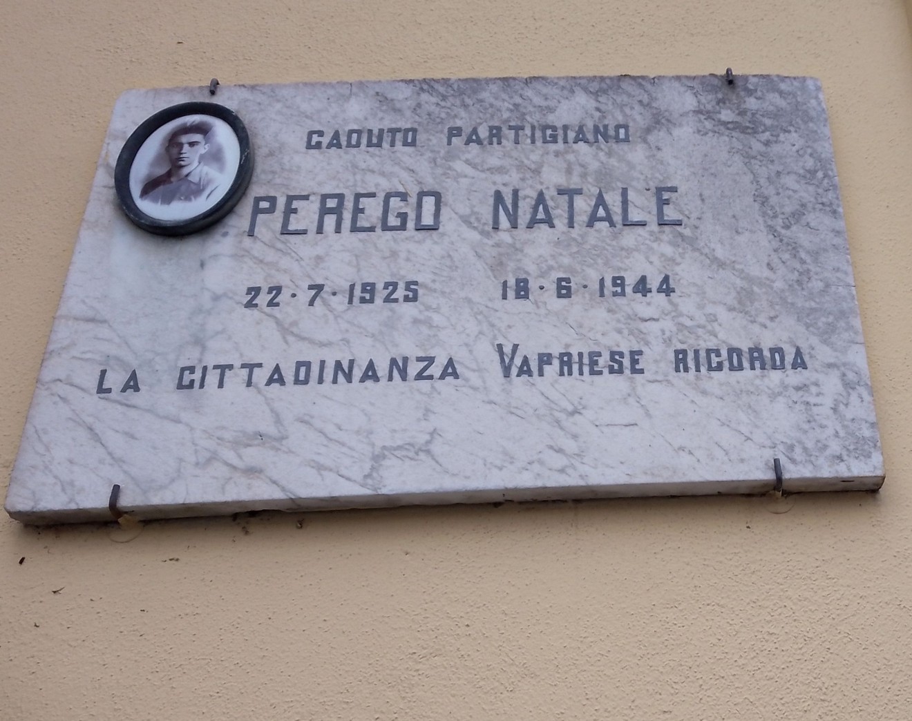 Lapide commemorativa a Perego, dedicata a Natale Perego, partigiano, con data di nascita e morte.
