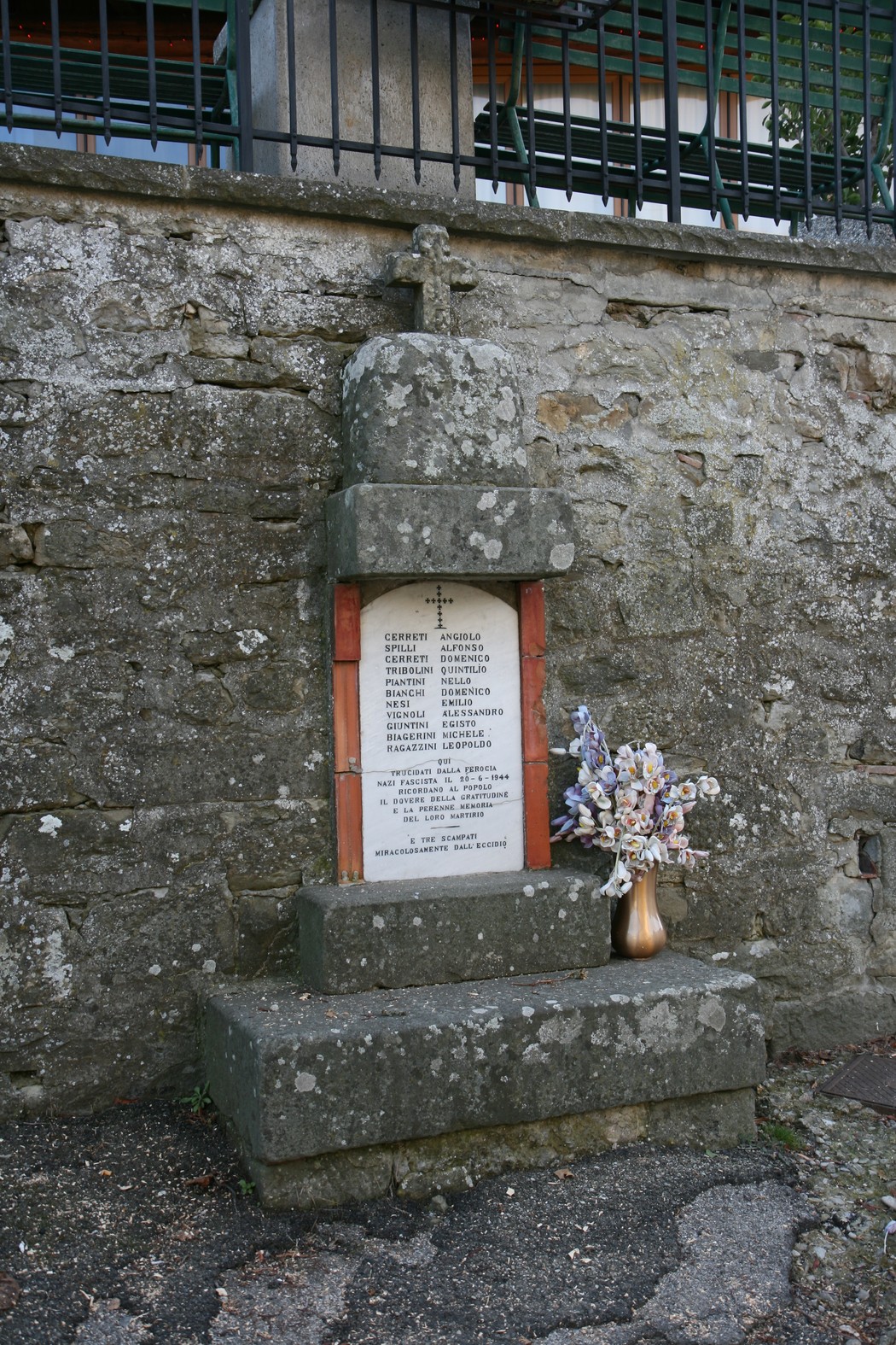 Lapide commemorativa della strage avvenuta al Castello, con fiori e decorazioni.