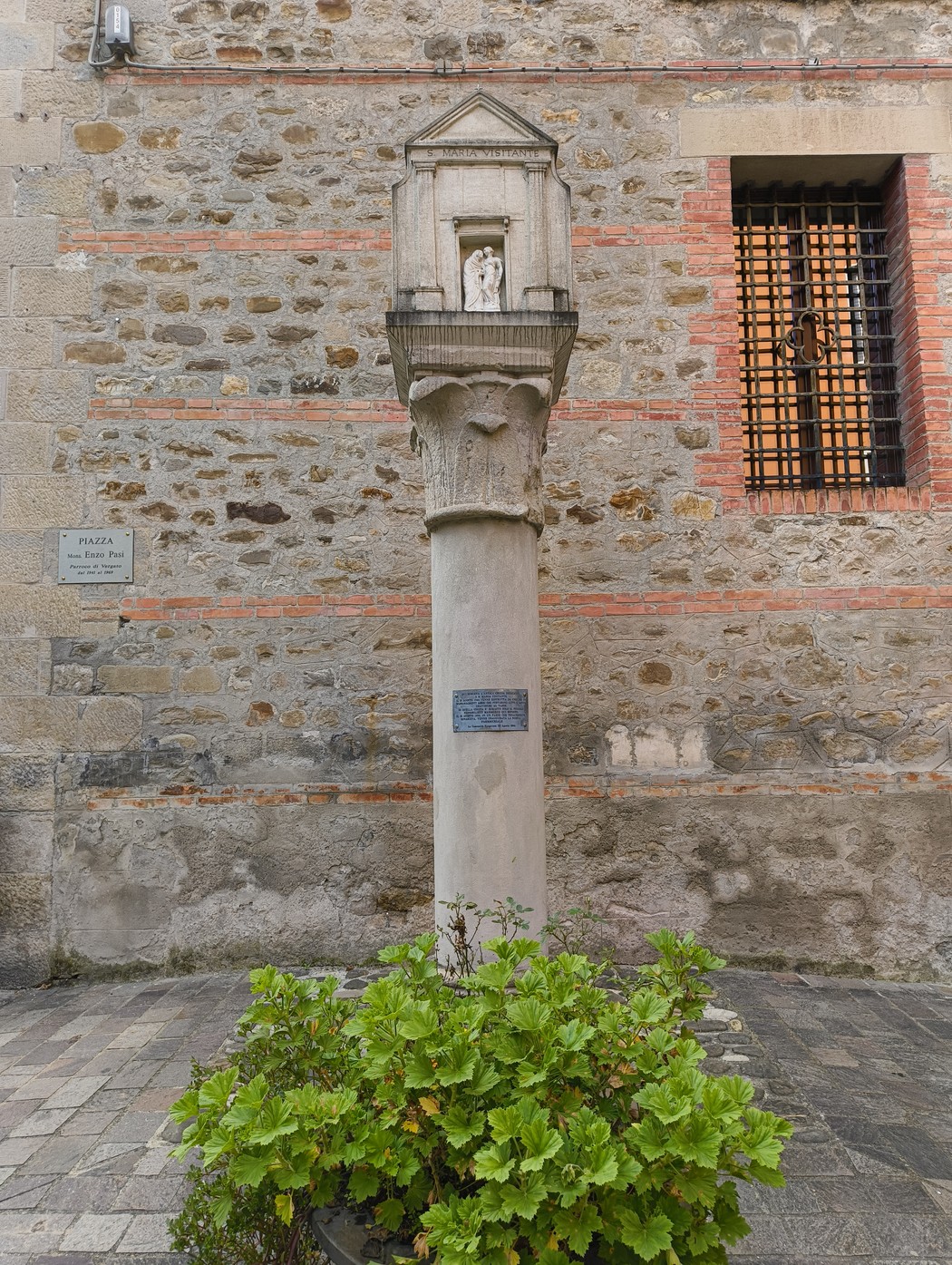 Colonna con statua dedicata a Santa Maria Visitante, incastonata in un contesto storico.