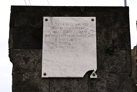 Lapide commemorativa per l'anniversario della Liberazione e delle Quattro Giornate, su fondo di pietra.
