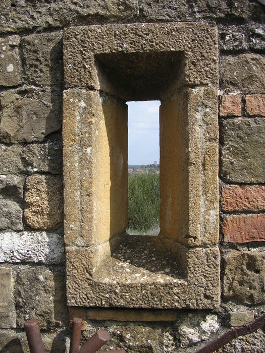 Dettaglio di una finestra del Monumento di Collo Sodo, realizzata in pietra, che offre una vista sul paesaggio circostante.