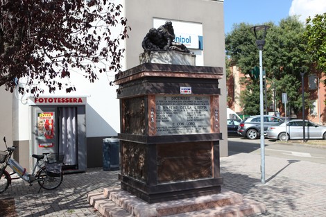 Monumento ai Martiri del Panaro, con una grande base e un'opera scultorea al centro, circondato da vegetazione e strade.