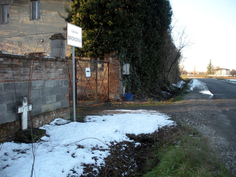 Immagine di un cartello stradale in un paesaggio invernale con neve e una strada che si biforca.