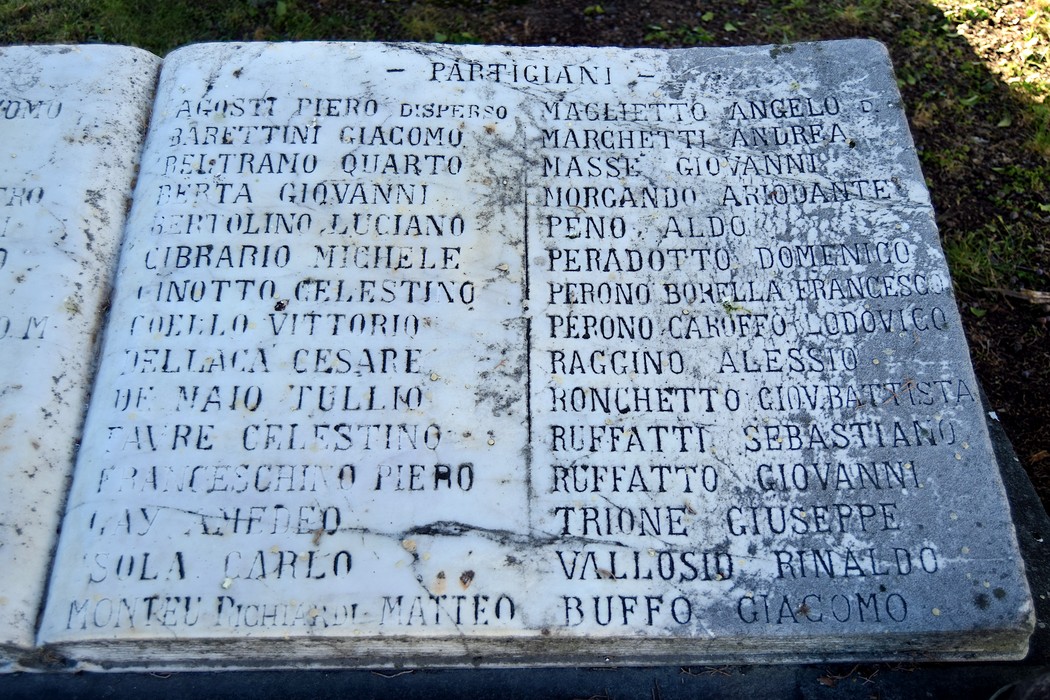 Monumento ai caduti con elenchi di nomi incisi su una stele commemorativa. Rappresenta il ricordo dei partigiani.
