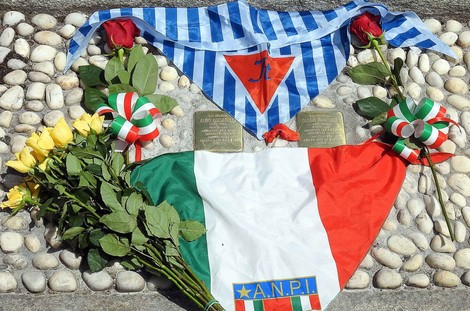 Pietre d'inciampo dedicate a Locatelli e Panigadi, con fiori e simboli nazionali in memoria delle vittime.