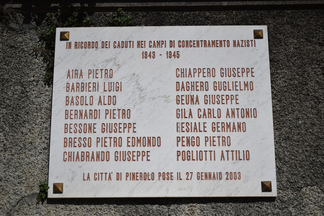 Lapide commemorativa dedicata ai caduti nei campi di concentramento nazisti, con nomi ed epoca di riferimento.